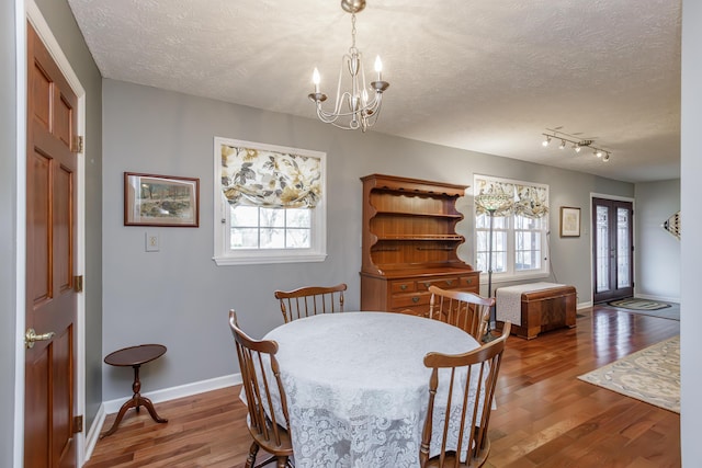 dining space featuring plenty of natural light, a textured ceiling, and wood finished floors