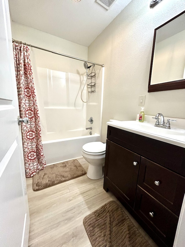 full bathroom with shower / tub combo with curtain, toilet, vanity, and wood finished floors