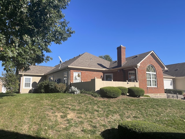 view of side of home with brick siding, a lawn, a chimney, and fence