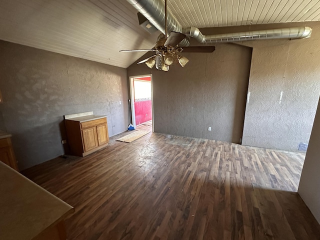 unfurnished living room with wood ceiling, wood finished floors, vaulted ceiling, and a textured wall