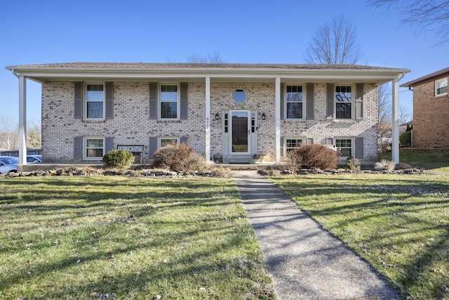 split foyer home featuring a front yard and brick siding