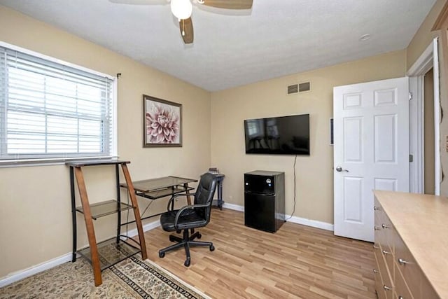 office with visible vents, baseboards, light wood-style floors, and ceiling fan