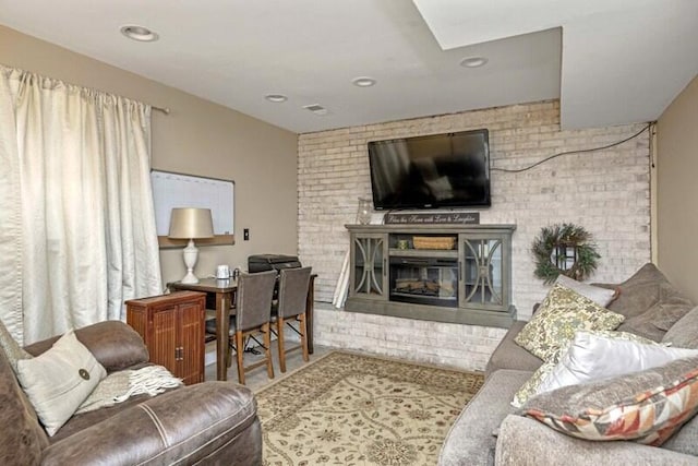 living area with visible vents and a glass covered fireplace