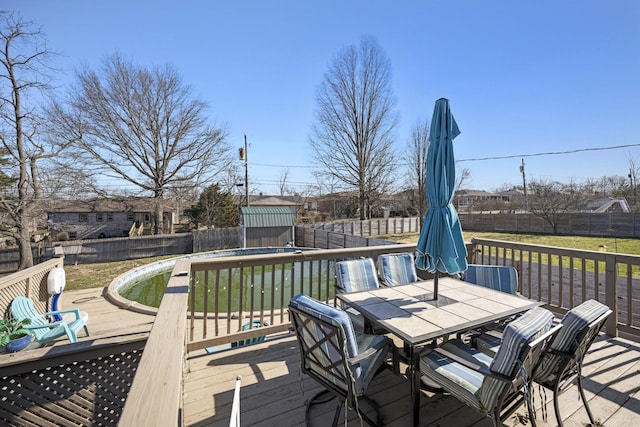 wooden terrace with outdoor dining space and a fenced backyard