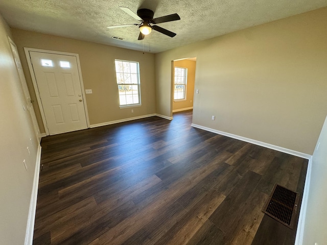 foyer featuring dark wood finished floors, baseboards, visible vents, and ceiling fan