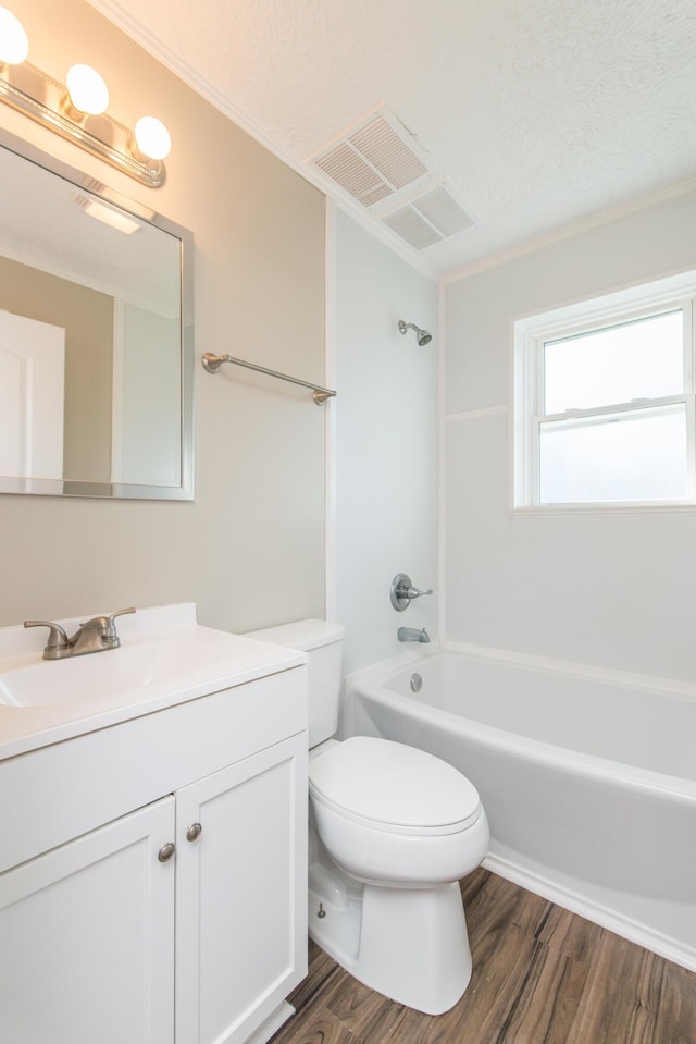 bathroom featuring visible vents, toilet, wood finished floors,  shower combination, and vanity