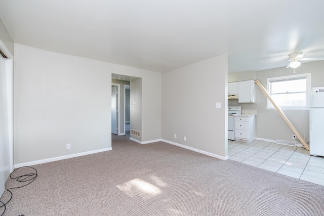 unfurnished living room featuring light tile patterned floors, visible vents, light colored carpet, and baseboards