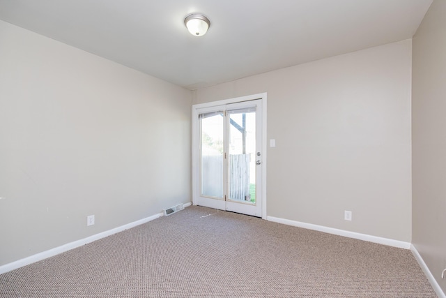 carpeted empty room with visible vents and baseboards