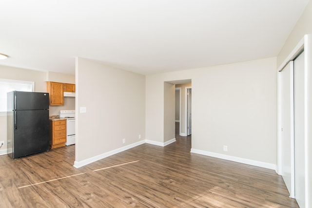 unfurnished living room with wood finished floors and baseboards