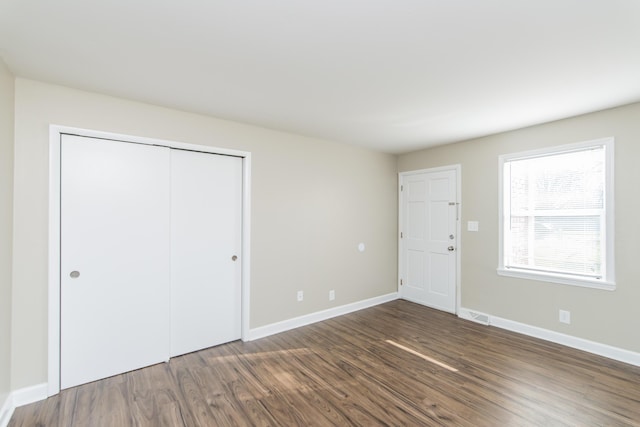 interior space featuring a closet, visible vents, baseboards, and wood finished floors