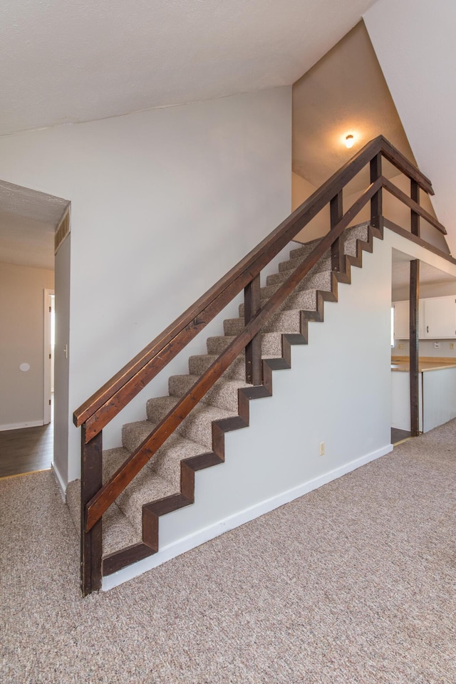 stairs featuring baseboards and carpet floors