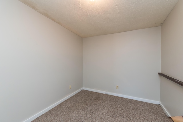 carpeted empty room with baseboards and a textured ceiling