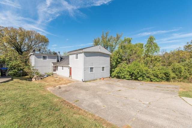 view of side of home featuring a yard and driveway