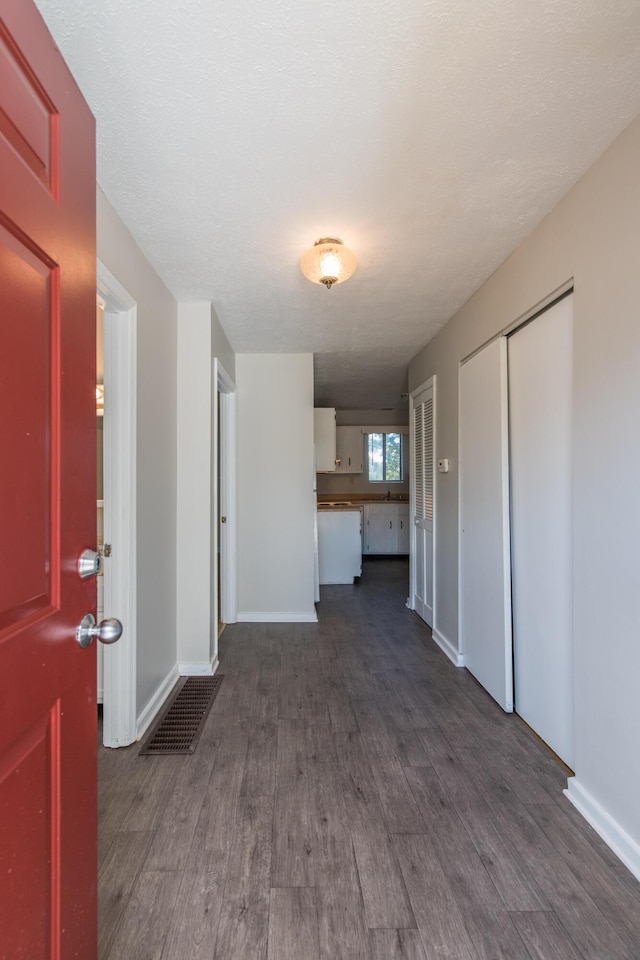 interior space with visible vents, baseboards, and dark wood-style flooring