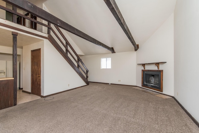 unfurnished living room with lofted ceiling with beams, carpet, a fireplace, and stairs