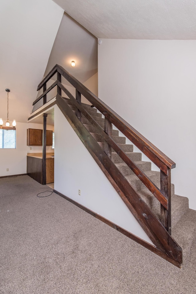 staircase with baseboards, carpet flooring, and vaulted ceiling