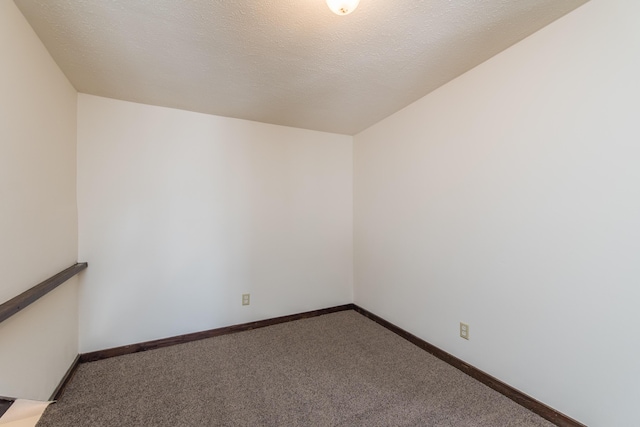 carpeted empty room with baseboards and a textured ceiling