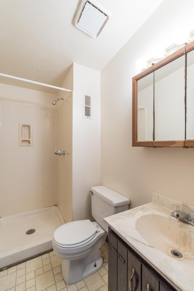 bathroom with visible vents, a stall shower, toilet, and vanity