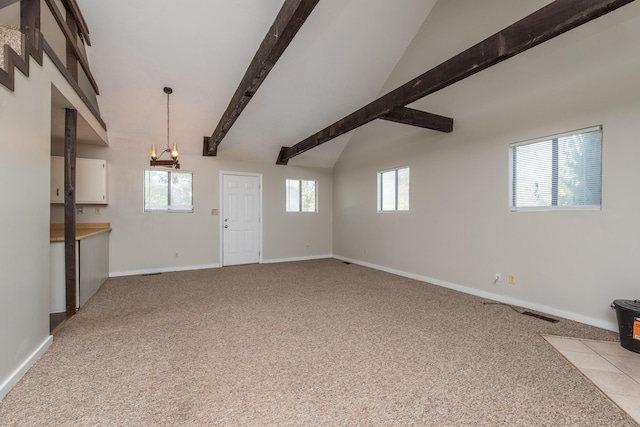 unfurnished living room featuring lofted ceiling with beams, baseboards, carpet floors, and a wealth of natural light