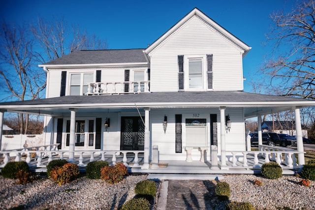 farmhouse inspired home with a porch and a shingled roof