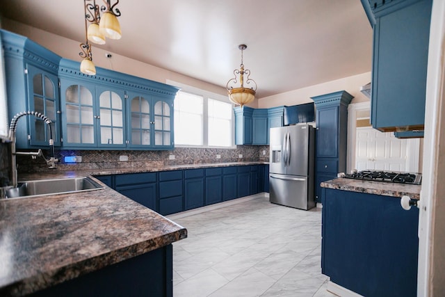 kitchen featuring blue cabinetry, decorative backsplash, stainless steel refrigerator with ice dispenser, gas stovetop, and a sink