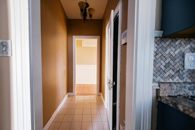 hallway with light tile patterned floors and baseboards