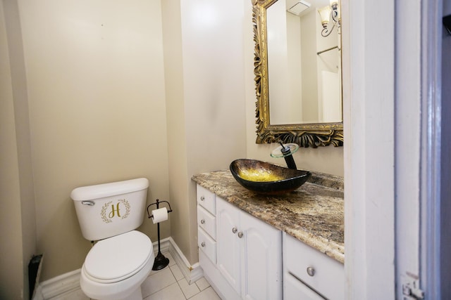 bathroom with baseboards, toilet, vanity, and tile patterned flooring