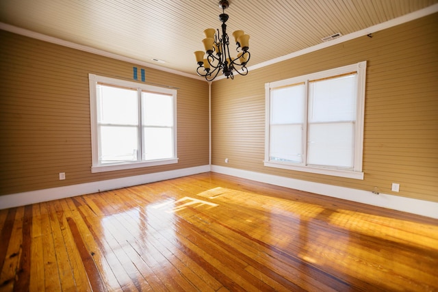 unfurnished room featuring light wood-style flooring, baseboards, crown molding, and an inviting chandelier