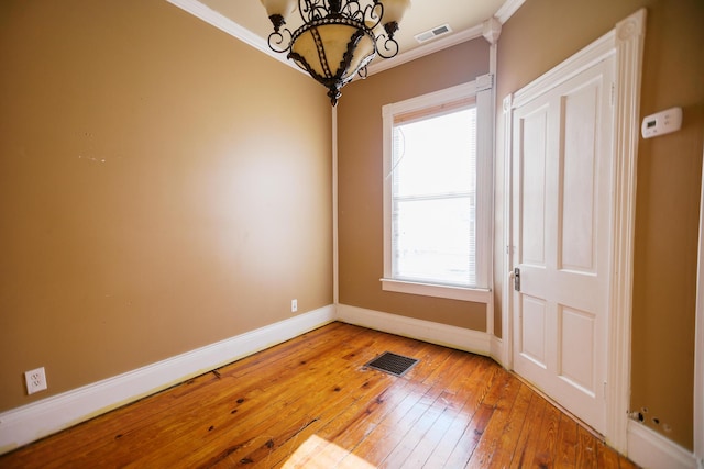 unfurnished room with visible vents, an inviting chandelier, and crown molding