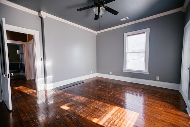 spare room with visible vents, baseboards, ceiling fan, wood-type flooring, and crown molding