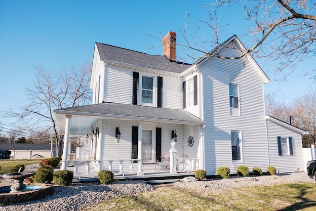 view of front of house with covered porch, roof with shingles, and a chimney