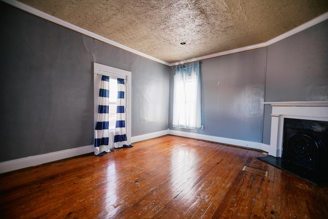 unfurnished living room featuring crown molding, baseboards, and hardwood / wood-style floors