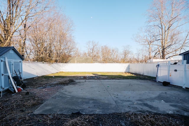 view of yard with a storage unit, a patio, an outdoor structure, and a fenced backyard