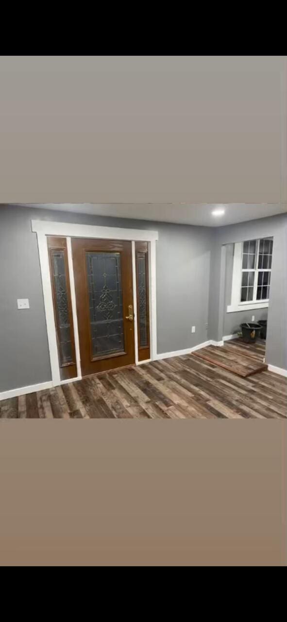 foyer entrance featuring baseboards and wood finished floors