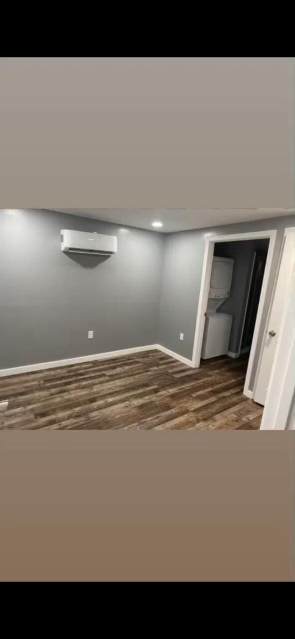 interior space with an AC wall unit, wood finished floors, and baseboards