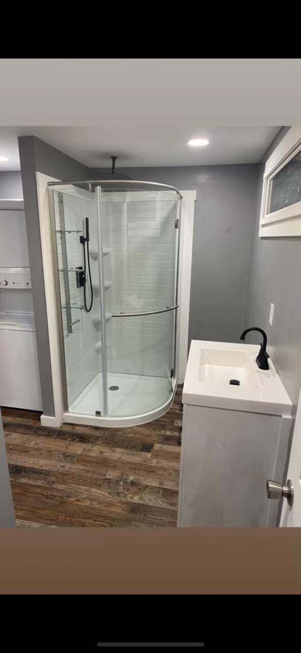 full bathroom featuring a shower stall, vanity, and wood finished floors