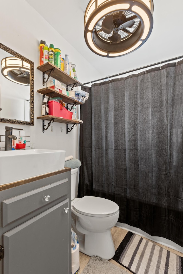 full bath with a shower with shower curtain, toilet, and vanity