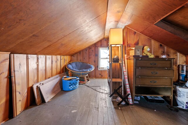 bonus room featuring hardwood / wood-style floors, lofted ceiling, and wood walls