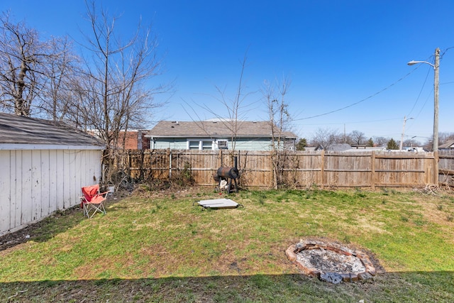 view of yard featuring a fire pit and a fenced backyard