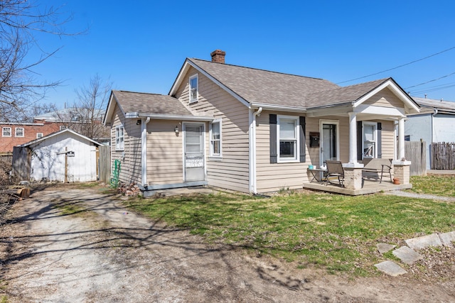 bungalow featuring an outbuilding, roof with shingles, a chimney, and fence