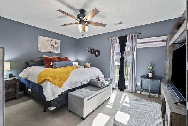 bedroom with visible vents, a ceiling fan, and carpet flooring