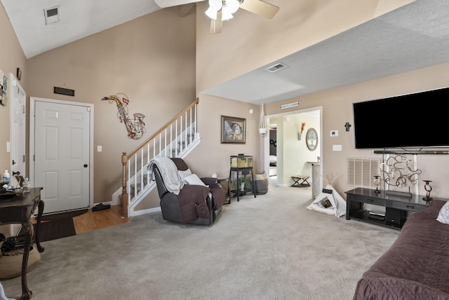 carpeted living room featuring stairs, a ceiling fan, and visible vents