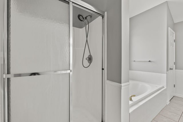 bathroom featuring tile patterned floors, a bath, and a shower stall