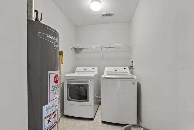 washroom featuring gas water heater, visible vents, laundry area, and washer and dryer