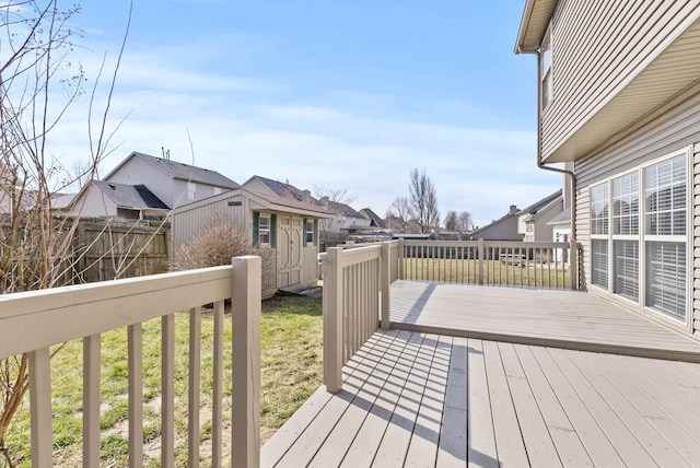 wooden deck with an outbuilding, a residential view, a storage unit, and fence