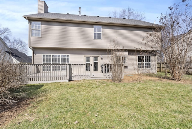 rear view of property featuring a yard, fence, and a chimney