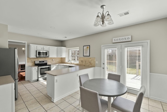 kitchen with light tile patterned floors, visible vents, an inviting chandelier, appliances with stainless steel finishes, and white cabinetry