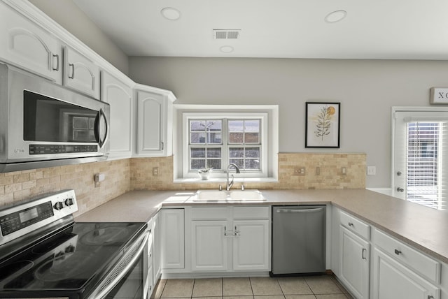 kitchen featuring a sink, visible vents, white cabinetry, and stainless steel appliances