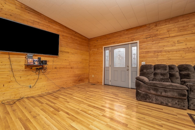 living area with lofted ceiling, wood finished floors, and wood walls