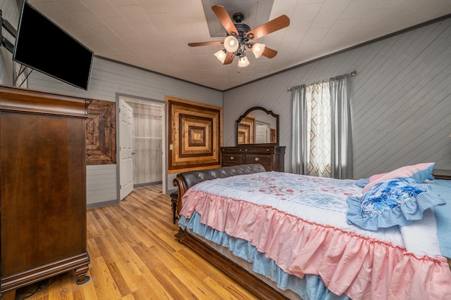 bedroom featuring a ceiling fan, light wood-style floors, and ornamental molding